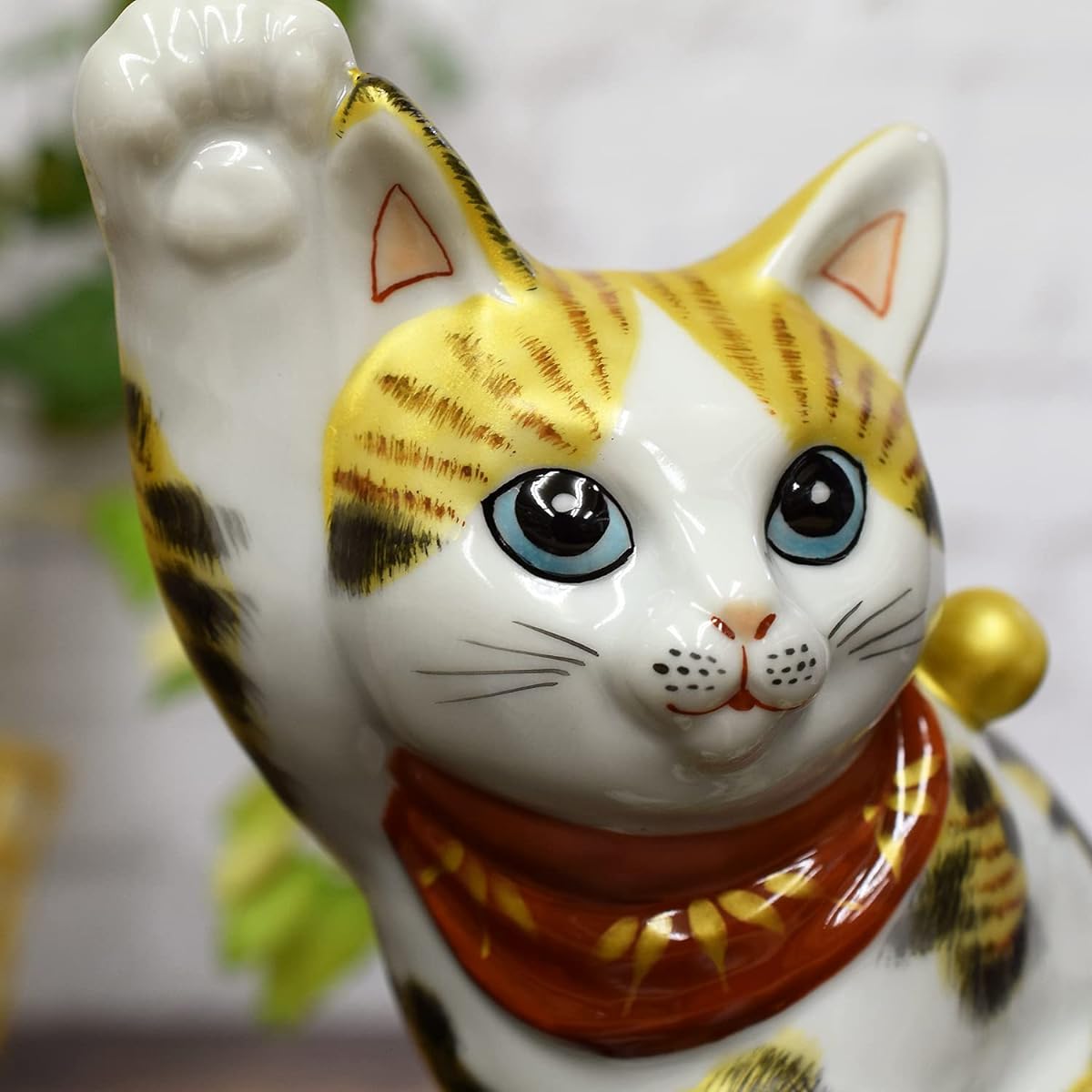 Kutani ware, right hand, side-sitting beckoning cat, golden calico